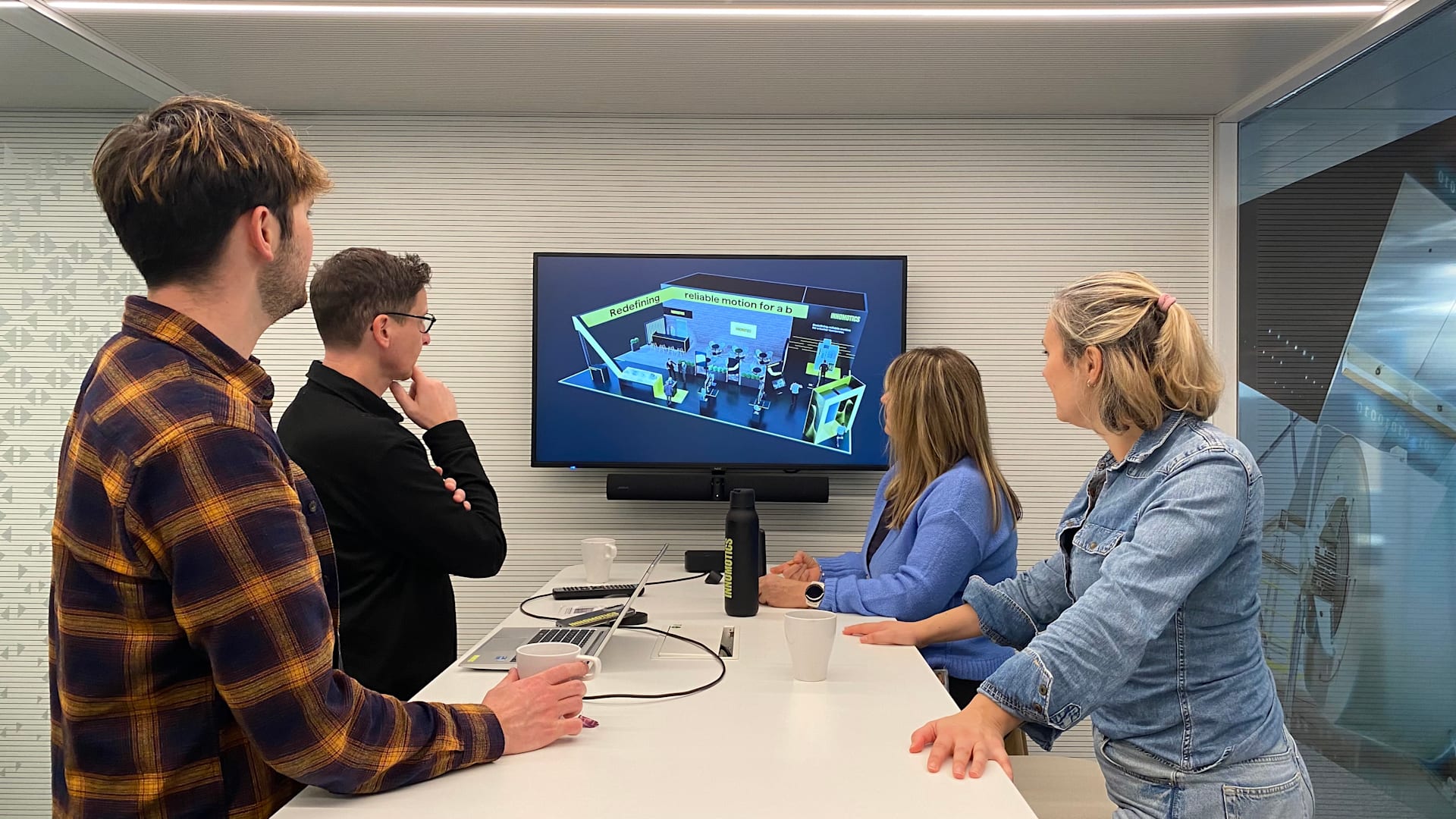 Event team looking at a big screen in a meeting room showing a rendering of a tradeshow booth